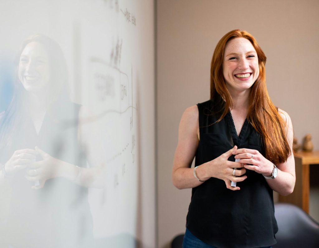 Confident businesswoman smiling during a corporate presentation in a modern office setting.